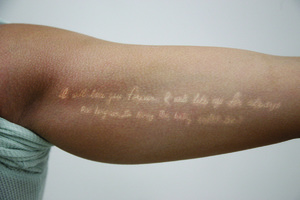 Alexandria Aruck's white ink tattoo reads, 